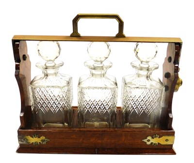 Lot 22 - An early 20thC oak and brass mounted tantalus,...