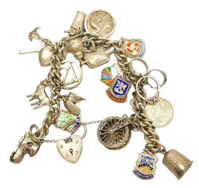 Lot 189 - A curb link charm bracelet, on a heart shaped...
