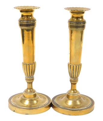 Lot 105 - A pair of Regency loaded brass candlesticks,...