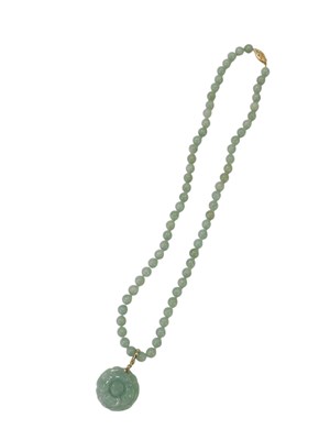 Lot 90 - A jade beaded necklace, with a carved flower...