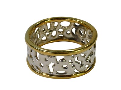 Lot 84 - A bicoloured metal bangle, of pierced abstract...