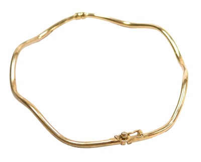 Lot 352 - A 9ct gold wavy design bangle, on a snap clasp,...