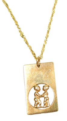 Lot 364 - A 9ct gold pendant depicting two figures in...