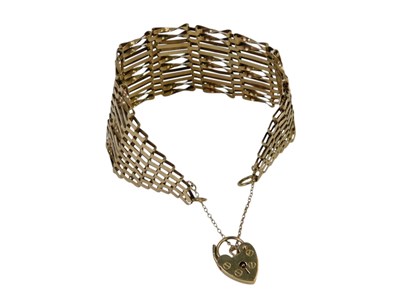 Lot 8 - A 9ct gold ten bar gate bracelet, with a heart-...