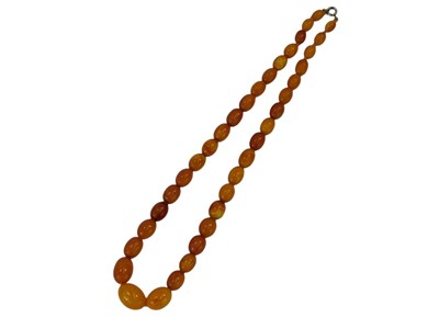 Lot 133 - A graduated amber beaded necklace, 44cm long,...