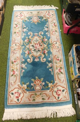 Lot 2139 - A Chinese wool blue ground rug, decorated with...