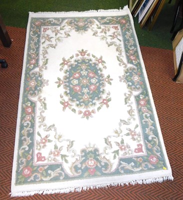 Lot 2191 - A cream ground wool rug, decorated with flowers.