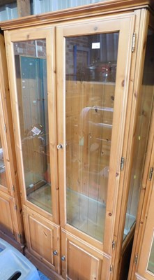 Lot 1136 - A varnished pine display cabinet, with two...