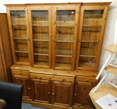 Lot 1050 - A pine breakfront display cabinet, the top...