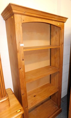 Lot 1067 - A pine open bookcase, the top with a moulded...