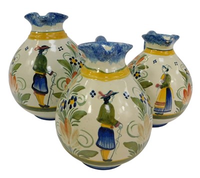 Lot 264 - Three Quimper ware jugs, each depicting Breton...