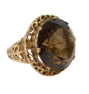 Lot 36 - A smokey quartz dress ring, in a claw setting...