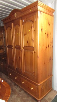 Lot 1009 - A large pine three door wardrobe, cornice over...