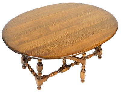 Lot 890 - An Ercol dark elm drop leaf coffee table,...