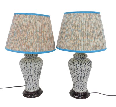 Lot 576 - A pair of blue and white pottery table lamp...