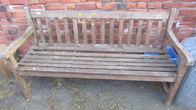 Lot 1142 - A two seater teak garden bench.