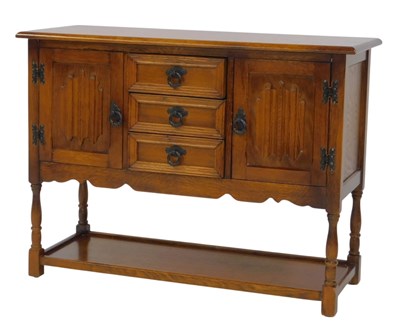 Lot 596 - An oak Old Charm style side cabinet, with...
