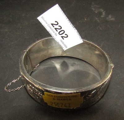 Lot 2202 - A silver bangle, with bright cut floral...