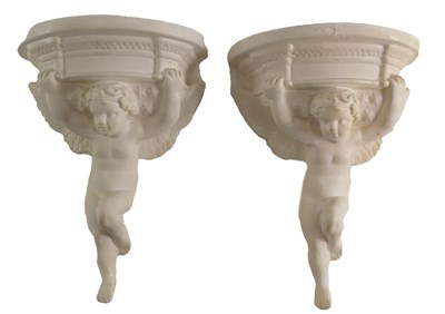 Lot 579 - A pair of plaster brackets, each with putto...