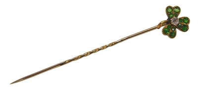 Lot 377 - A diamond and tzsavorite shamrock tie pin, in...