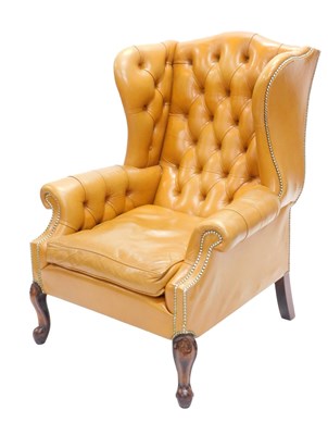 Lot 42 - A tan leather wing back chair in George III...