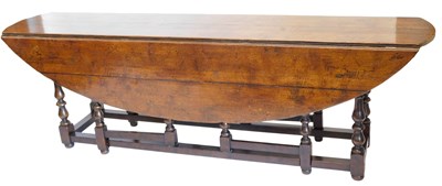 Lot 41 - A large oak oval drop-leaf wake table, with a...