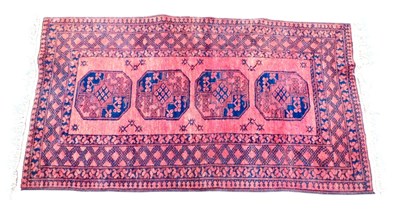 Lot 821 - An Afghan red ground rug, with four central...