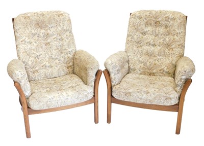 Lot 877 - A pair of Ercol elm armchairs, each with...