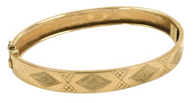 Lot 101 - A 9ct gold bangle, with engraved decoration,...