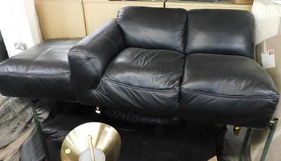 Lot 1048 - A black leather L shaped sofa, with footstool.