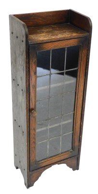 Lot 473 - An early 20thC oak bookcase, with a glazed...