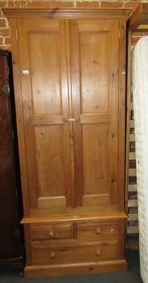 Lot 1027 - A pine double wardrobe, with one short and two...