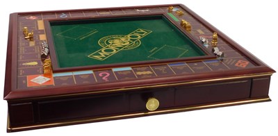 Lot 343 - A wooden Monopoly board, together with playing...