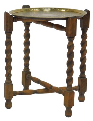 Lot 567 - A Middle Eastern brass tray top table, on a...