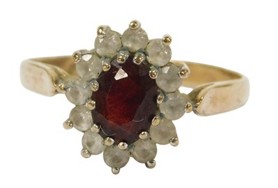Lot 311 - A dress ring, florally claw set with oval red...