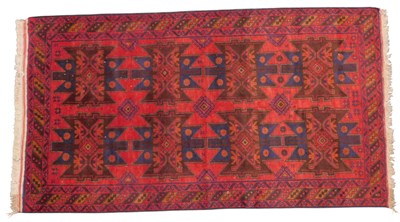 Lot 692 - A Baluch rug, red ground, with two rose...