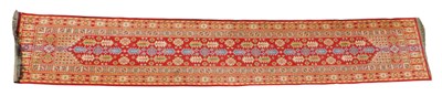 Lot 697 - A red ground runner, decorated centrally with...