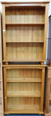 Lot 1184 - A pine bookcase of three shelves, raised on...