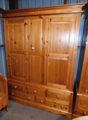Lot 1009 - A pine triple wardrobe, the top with a moulded...