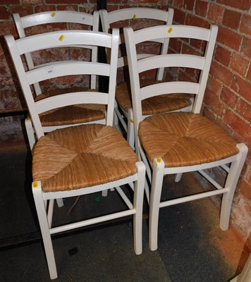 Lot 1057 - Four white painted rush seated kitchen chairs.