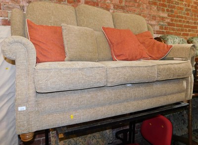 Lot 1114 - A brown upholstered three seater sofa, with...