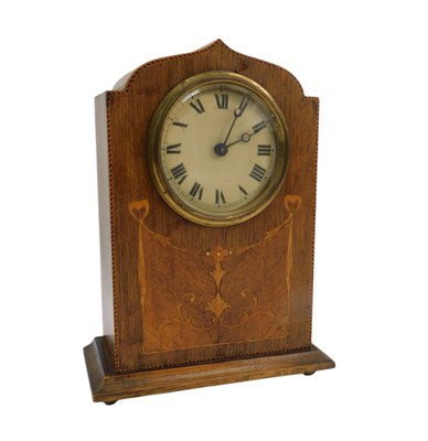 Lot 55 - An Edwardian oak and inlaid mantel clock, the...