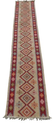 Lot 674 - A Turkish Kilim runner, cream ground, with a...