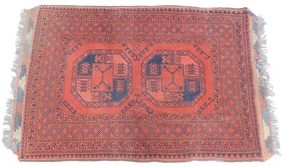 Lot 673 - An Afghan rug, red ground, with two medallions...