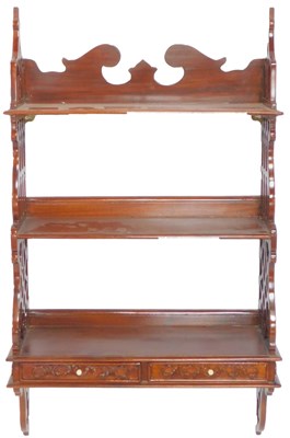 Lot 640 - A mahogany three-tier wall shelf, with a...