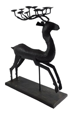 Lot 108 - A hammered metal candle stand, formed as a...