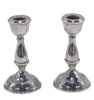 Lot 249 - A pair of silver candlesticks, of stylised...