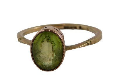 Lot 333 - A peridot dress ring, the oval peridot in a...