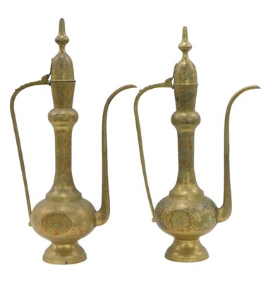 Lot 553 - A pair of large Middle Eastern brass jugs,...