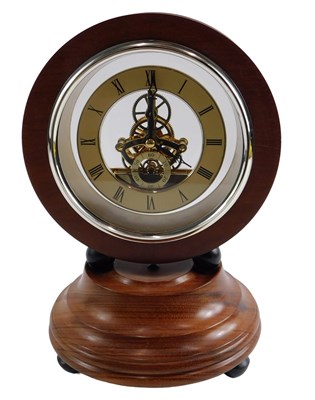 Lot 557 - A hardwood mantel clock, the circular apricot...